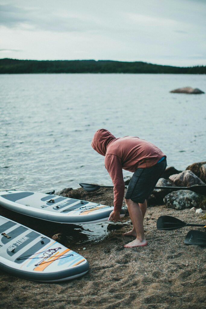 Person picking up a Surfboard